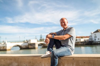 Turistik ve tarihi Tavira, Algarve, Portekiz 'de nehir kenarında dinlenen gülümseyen adamın portresi