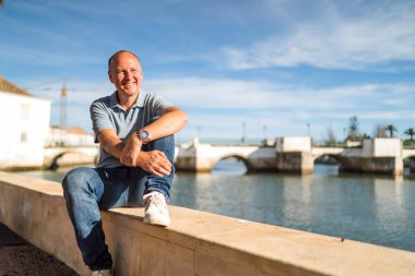Turistik ve tarihi Tavira, Algarve, Portekiz 'de nehir kenarında dinlenen gülümseyen adamın portresi