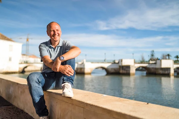 Turistik ve tarihi Tavira, Algarve, Portekiz 'de nehir kenarında dinlenen gülümseyen adamın portresi