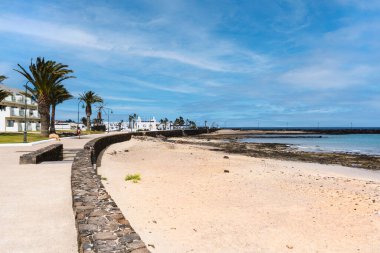 Los Charcos beach with white sand and volcanic rocks in Costa Teguise in Lanzarote, Canary Island, Spain