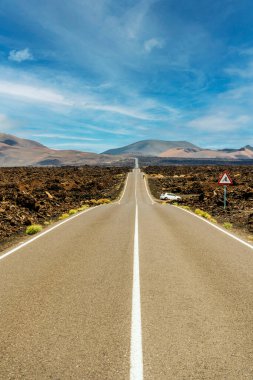 Timanfaya Ulusal Parkı, Lanzarote, Kanarya Adaları, İspanya 'nın volkanik kurak arazisinde asfalt yol