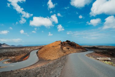 Timanfaya Ulusal Parkı, Lanzarote, Kanarya Adaları, İspanya 'nın volkanik kurak arazisinde asfalt yol