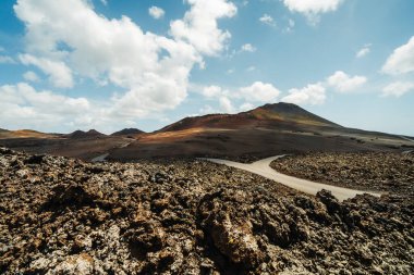 Timanfaya Ulusal Parkı, Lanzarote, Kanarya Adaları, İspanya 'nın volkanik kurak arazisinde asfalt yol
