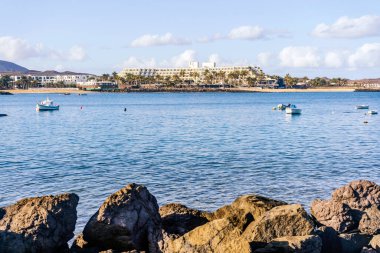 Önünde tekneleri olan Costa Teguise adlı tatil köyü Lanzarote, Kanarya Adası, İspanya