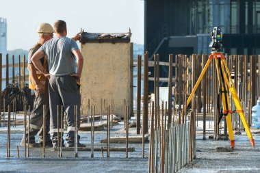 Kiev, Ukrayna - 10 Eylül 2019: Bir konut binasının şantiyesinde aktif hazırlık çalışmaları devam etmektedir. Eksper mühendisi teodolit ile çalışıyor.