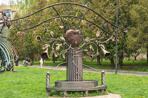 Ровно, Украина - 4 мая 2019 года: Прекрасная металлическая скульптура в весеннем парке в виде большого сердца и десятков маленьких сердец.