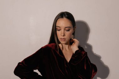 Neşeli genç bir kadın izole edilmiş arka plana bakıyor. Bej arka planda izole edilmiş inanılmaz zarif Avrupalı kızın stüdyo çekimi.