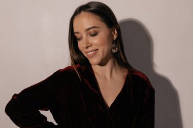 Koyu renk saç stili, şenlikli elbisesi ve izole edilmiş arka planda altın kazancı olan zarif ve şık bir kadının portresi. Tatiller, yeni yıl, doğum günü