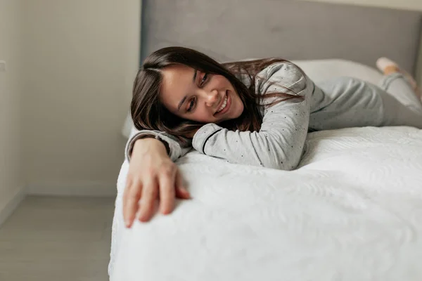 Senyum Santai Gadis Dengan Rambut Bergelombang Gelap Berbaring Tempat Tidur — Stok Foto