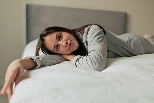 Wanita Bahagia Manis Dengan Rambut Hitam Mengenakan Setelan Rumah Berbaring — Stok Foto