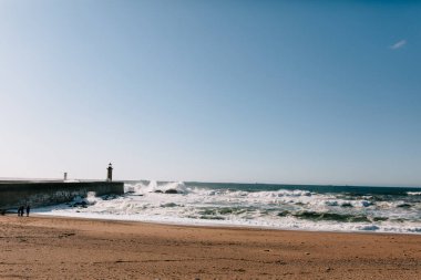 Okyanusta dalgalar ve deniz fenerleriyle dolu harika bir sahil okyanusu fotoğrafı. Portekiz okyanusunun güzel doğası. Yüksek kalite fotoğraf