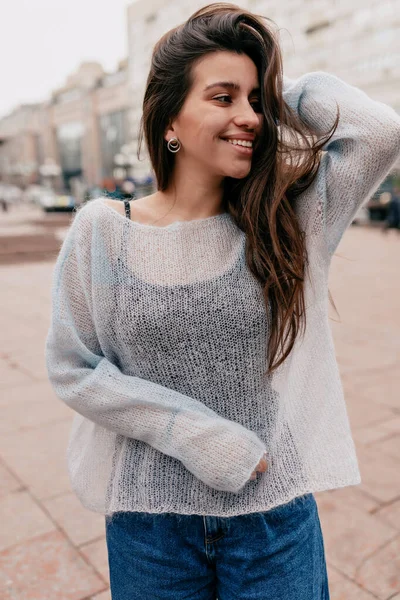 Atractiva mujer de pelo largo europea con una sonrisa encantadora usando suéter azul claro. — Foto de Stock
