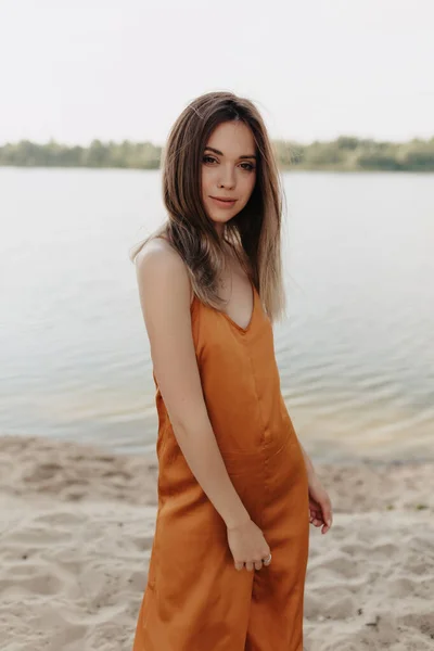 피부가 소녀가 카메라를 놀라운 모습의 주변에서 주황색 선드레스를 여성의 — 스톡 사진
