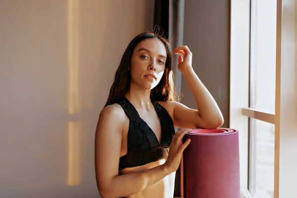 Slim Wanita Berseragam Olahraga Berpose Kamera Dengan Tikar Yoga Dekat — Stok Foto