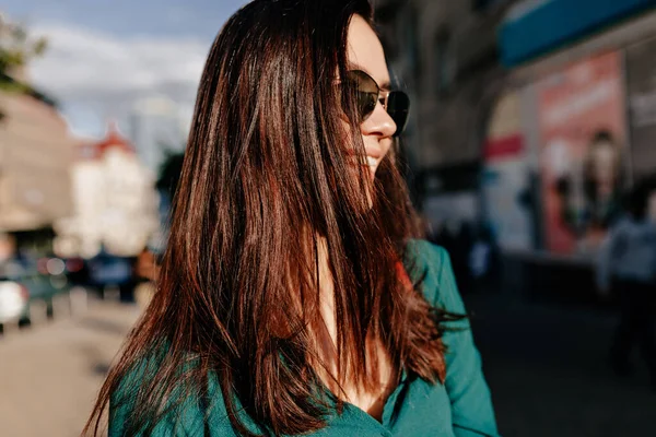 Güneş gözlükleriyle gülümseyen, güzel, gülümseyen bir kadının portresi. Güneşli caddede yürürken. Yüksek kalite fotoğraf