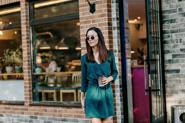 드레스와 선글라스를 유행하는 매력적 여자가 커피를 마시고 공원을 산책하며 주말을 — 스톡 사진