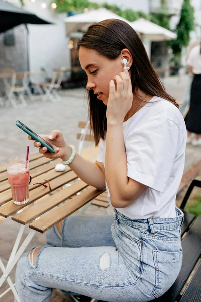 Wanita Menawan Dengan Kaos Putih Dan Celana Jeans Menyentuh Headphone — Stok Foto