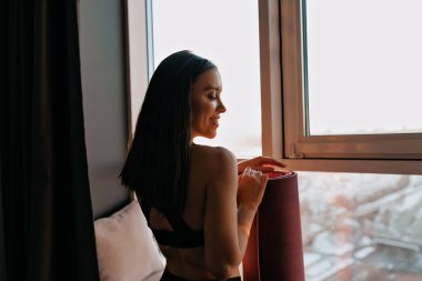 Çekiciliğin arka tarafındaki portreyi yakın çekimde karşıt ışıkta yoga minderini tutarken ve sabah sporuna hazırlanırken.. 