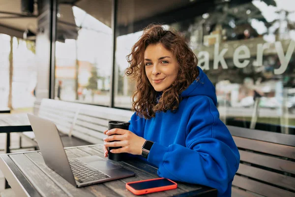 Gadis Muda Kaukasia Minum Kopi Pagi Hari Dan Menggunakan Laptopnya — Stok Foto