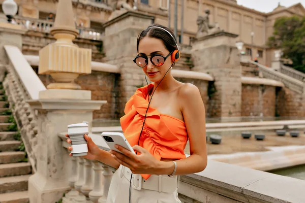 Excited Brunette Orange Blouse Poses Background Historical Architecture Listening Music — Stok Foto