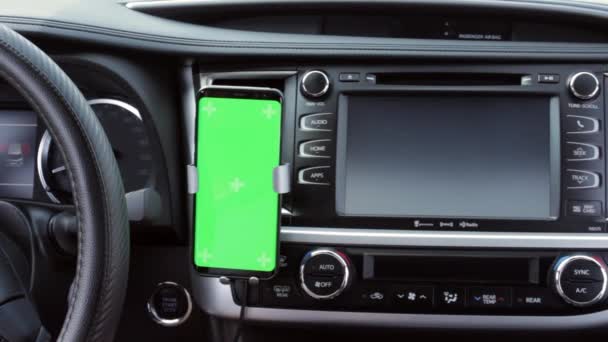 Närbild av smartphone med grön skärm på instrumentbrädans bilpanel. Navigerar app. Chromakey förlöjligar. Sociala nätverk. Gps karta. — Stockvideo