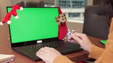 Genç bir kadın arkadaşlarıyla görüntülü görüşmede konuşuyor ve elleri merkez ofisteki kamerada görülüyor. Sanal Noel partisi toplantı ekibi telgraf çekiyor. Uzak konferans Bilgisayar yeşil ekran görüntüsü.
