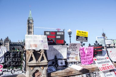 Parlamento binasının çitleri protesto işaretleriyle kaplı. Ottawa şehir merkezinde özgürlük konvoyu 2022, COVID-19 aşısına karşı Kanada 'da Ottawa Ontario, Kanada - 13 Şubat 2022
