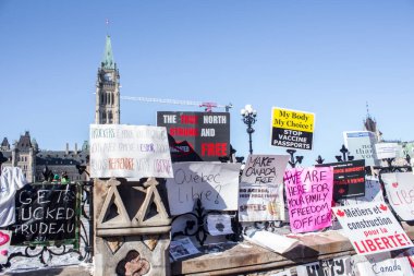 Parlamento binasının çitleri protesto işaretleriyle kaplı. Ottawa şehir merkezinde özgürlük konvoyu 2022, COVID-19 aşısına karşı Kanada 'da Ottawa Ontario, Kanada - 13 Şubat 2022