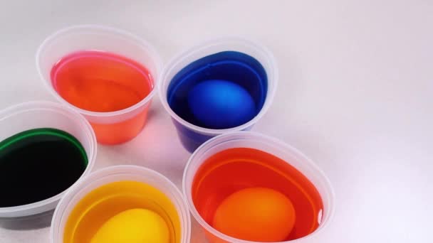 Ljusa färgglada glasögon med färg för ägg dekoration. Färgglada ägg dekorera färg på ett vitt bord. — Stockvideo