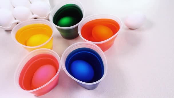 Ljusa färgglada glasögon med färg för ägg dekoration. Färgglada ägg dekorera färg på ett vitt bord. — Stockvideo