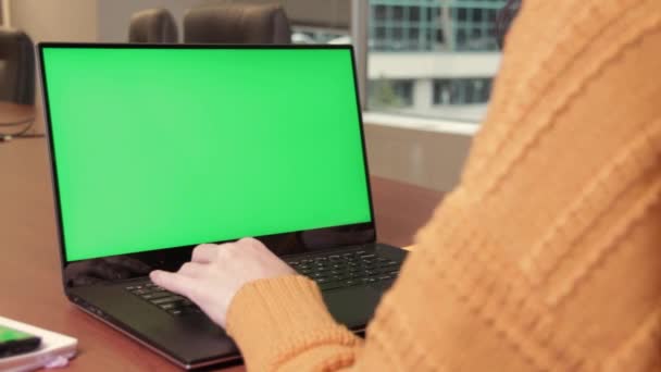 Jonge vrouw typt op laptop, neemt vergrootglas om iets te onderzoeken op groen scherm, breng het dichterbij. Chroma sleutel, model. — Stockvideo