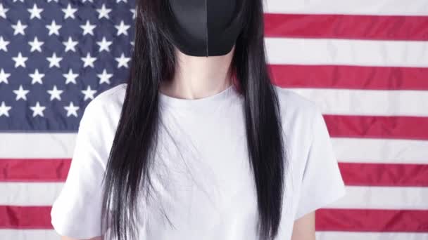 黒いフェイスマスクの若い女性は 私の体で段ボールを保持しています背景にアメリカの国旗に対する私の選択のサイン 反中絶法に抗議する少女 フェミニストの力 女性の権利の自由 — ストック動画