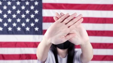 Ciddi kız avucunu kameraya uzatıp arka planda kürtaj Amerikan bayrağını durdurun diyor. Kapatın. Aile içi şiddet, ırkçılık ayrımcılığı. Kadın hakları için mücadele, sosyal sorunlar