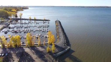 Aerial drone flight over Aylmer Harbor Marina in Gatineau, QC, Canada during Autumn. Fall drone footage. Flying over the pier at marina and the lighthouse