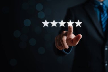 Müşteri işadamı, memnuniyet değerlendirme anketi ve gözden geçirme için sanal ekranda beş yıldızlı resimlere dokunuyor.