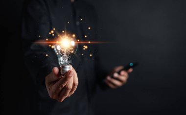 Yeni fikirleri sunmak için elinde ampul tutan bir iş adamı büyük bir ilham kaynağı ve yenilikçi yeni bir başlangıç. yaratıcı akıllı düşünceler ve yenilikler.