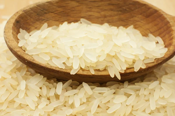 Ρύζι χυθεί στο τραπέζι και ένα ξύλινο κουτάλι — Φωτογραφία Αρχείου