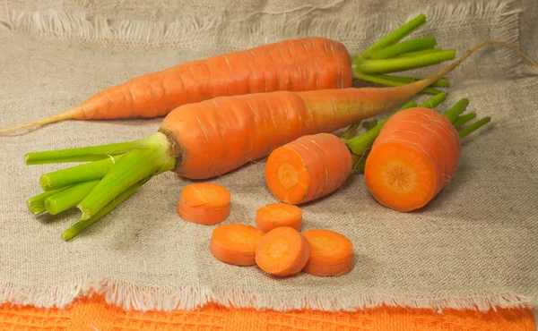 新鲜胡萝卜和胡萝卜在画布上的切片 — 图库照片