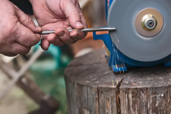 Sharpening of iron by abrasive disk machine. — Stock Photo, Image