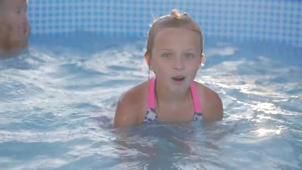 Щасливі діти, які плавають у басейні. друзі люблять грайливо плавати разом у сонячний день насолоджуючись прохолодною водою на літніх канікулах — стокове відео