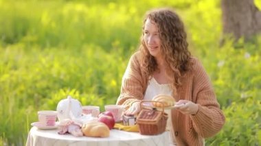 Piknikte aşık güzel bir çift. Genç bir manken ve gülümseyen güzel bir adam. Yaz ve bol yeşillik. Elbiseli kıvırcık bir kız gülümsüyor. Genç, güzel insanlar..