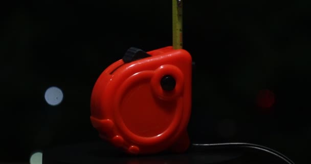 Κατασκευή Κόκκινη Πλαστική Ταινία Μέτρησης Περιστρέφεται Μαύρο Φόντο Εργαλείο Μέτρησης — Αρχείο Βίντεο