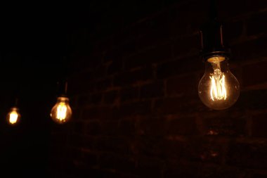 Duvarın arkasında dekoratif antika Edison tarzı ampuller var. Ampulleri aç.