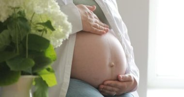 Hamile bir kadının göbeği. Hamile bir kadın karnına dokunuyor. Sağlıklı Hamilelik Annelik Konsepti. Anne elleri hamile karnında. Bebek bekliyor, mutlu aile, bebek 4 bin bekliyor..