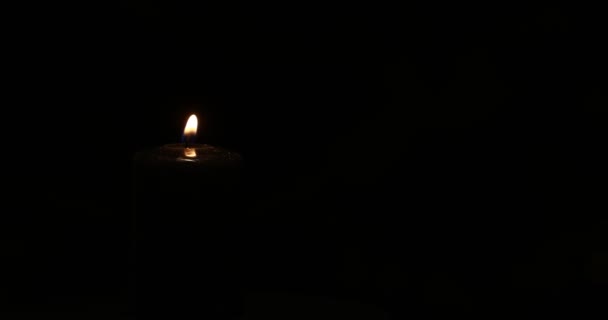Lumânare Neagră Aprinsă Învârte Fundal Întunecat Close — Videoclip de stoc