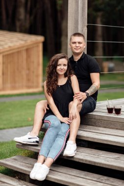 Mutlu çift güneşli yaz gününün tadını çıkarıyor. Genç mutlu adam ve kadın soğuk içecekler içiyor sokak kafesinde oturuyor..