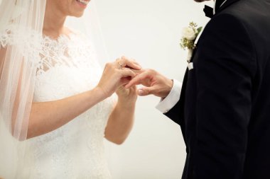 Evlilik yüzükleri. Nikah yüzüğünü He 'ye taktı. Gelin, Yüzüğü Damada Giydir. Thai düğün töreni ve Tayland düğün süsü. Gelin, damadın parmağına yüzüğü tak.