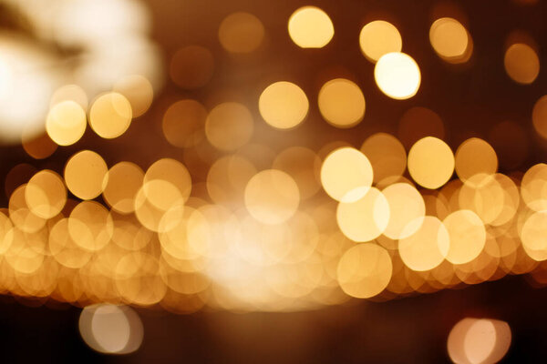 Christmas gold background. Festive abstract background with bokeh defocused lights.