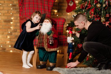 Baba ve küçük çocuk evde eğleniyor ve birlikte oynuyorlar. Portre seven aile yakınlaşır. Mutlu bir baba ve Noel ağacının yanında tatlı bir kız çocuğu. Mutlu Noeller ve mutlu tatiller