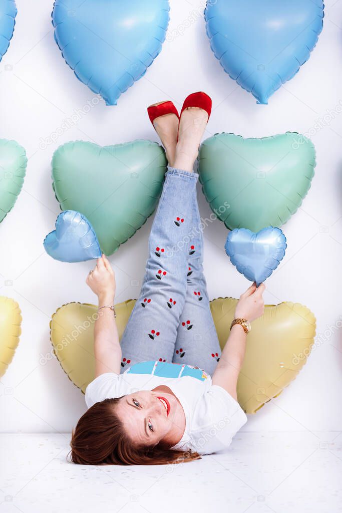 beautiful young woman on many colorful heart balloons background. smiles,funny Valentine s Day birthday party